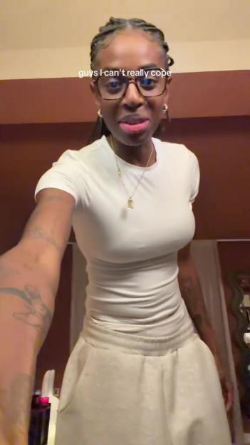 Cat Burns wearing a tight white top and light-colored pants.