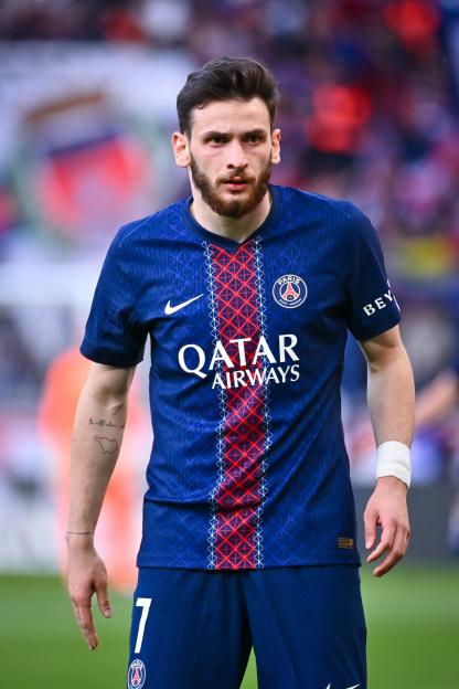 A player for Paris Saint-Germain, wearing a blue jersey with Qatar Airways sponsorship, looks toward the camera.