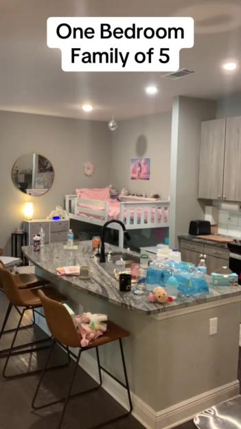 A kitchen with a bunk bed set up in the background.