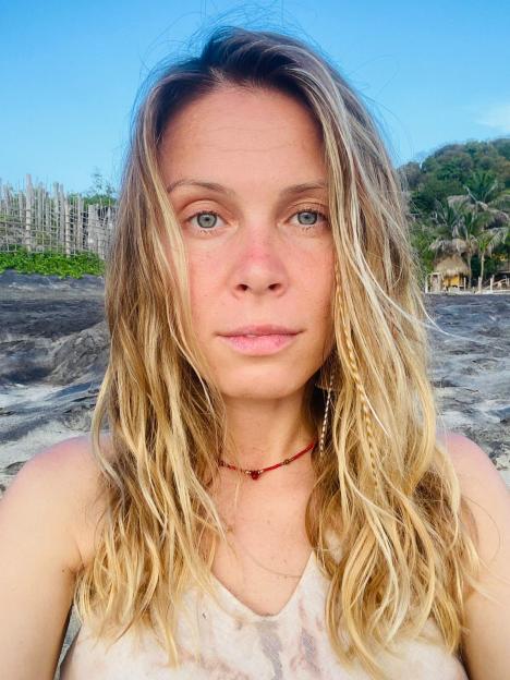 Close-up of Maria Sky on a beach, her long blonde hair framing her face.