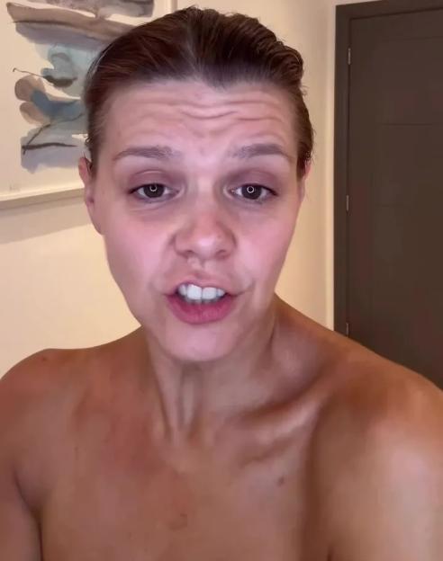 Woman with wet hair looks into the camera, speaking without makeup.