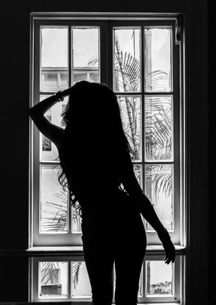 Silhouette of a young Mexican woman against a window
