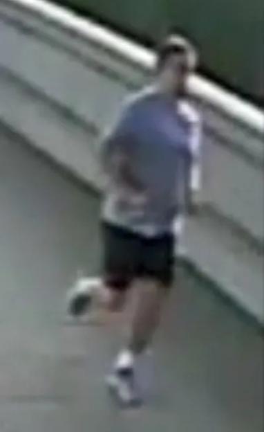 Police-issued image of a jogger in a t-shirt and shorts running on a street.