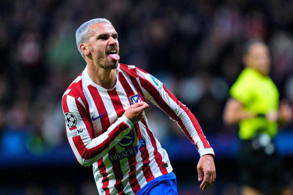 Antoine Griezmann celebrates a goal, sticking out his tongue and pointing to his jersey, during a UEFA Champions League match.