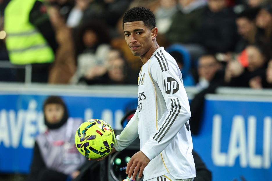 Real Madrid player Jude Bellingham holding a soccer ball during a LaLiga EA Sports match.
