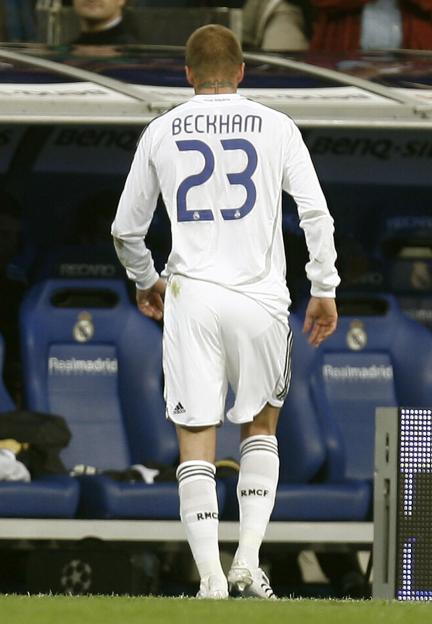 David Beckham, in a white Real Madrid jersey with the number 23, walks off the pitch.