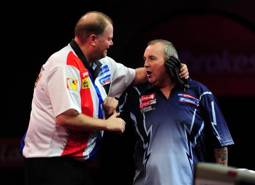 Phil Taylor and Raymond Van Barneveld celebrating during a darts match.