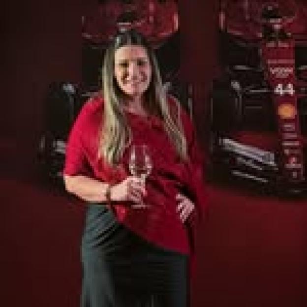 Bianca Naufel Saliba, a Brazilian businesswoman, smiling and holding a wine glass.