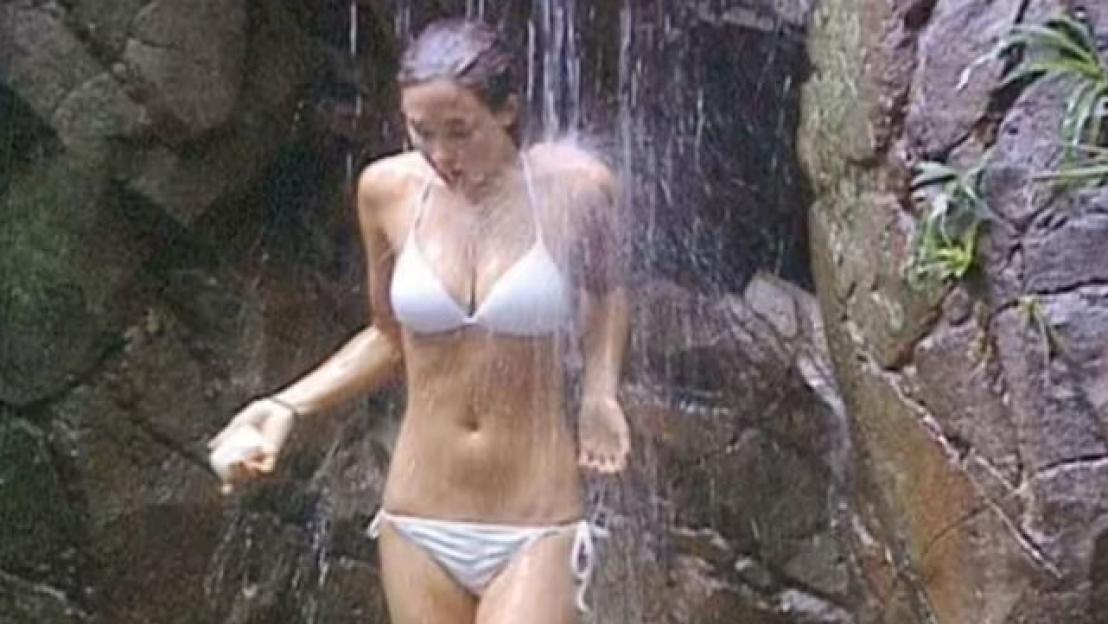 Myleene Klass in a white bikini under a shower.