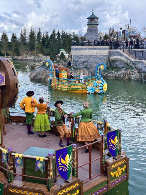 Performers in traditional clothing on a boat in a Disney Frozen preview.