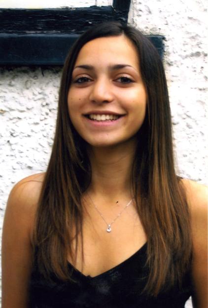 Meredith Kercher, a young woman with long dark hair, smiling at the camera.