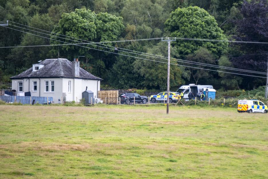 Police activity surrounding a rural property.