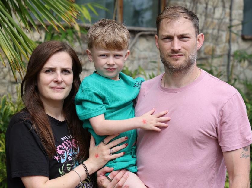 Noah Gooders held by his parents, Charlotte and Jason.