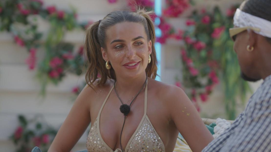 Toni Laites in a sequined bikini top with glitter on her face and Cacherel Mirjah Mercer, seen from behind, on Love Island.