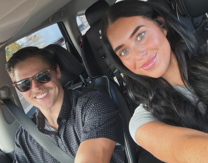 Madison Loftin and Kyle Loftin in a car, with Kyle in the driver's seat and Madison taking a selfie.