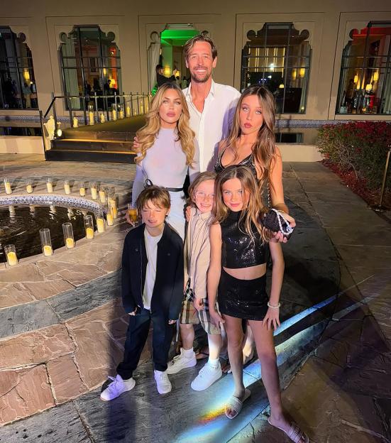 Peter Crouch, Abbey Clancy, and their four children stand together for a family photo.