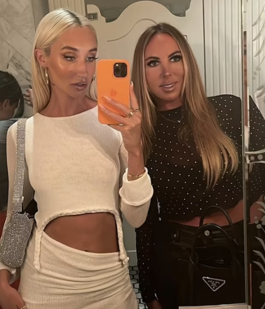 Two women taking a mirror selfie.