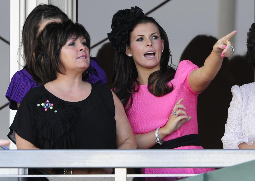 Rooney, wife of Manchester United's Rooney, points during the final day of the Grand National meeting at Aintree Racecourse in Liverpool