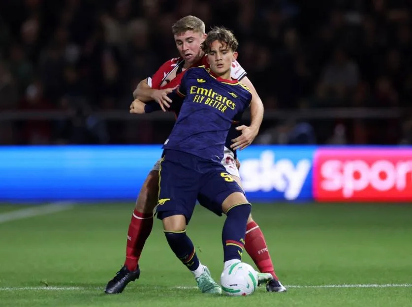 Max Dowman of Arsenal is challenged by Harrison Neal of Fleetwood Town during a match.