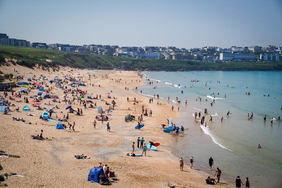 People enjoying the sun at Fistral beach, Newquay, Cornwall.