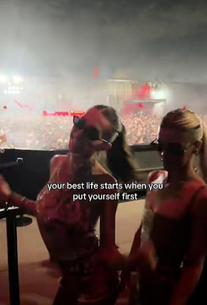 Two women dancing at a concert with the text "your best life starts when you put yourself first" overlaid.
