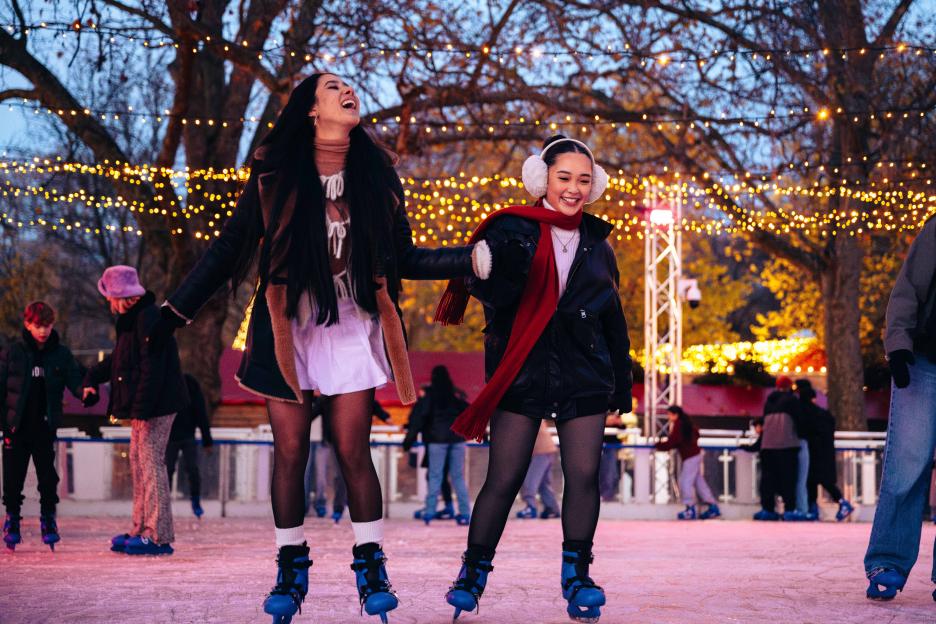 Two young women ice skating and laughing at Winter Wonderland 2025.