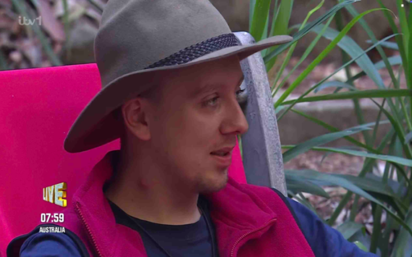 Aitch wearing a hat and a red fleece.