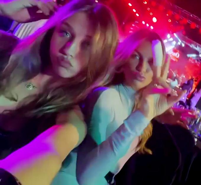 Sophia Crouch and Abbey Clancy at an event, with Sophia holding a phone and Abbey making a peace sign.