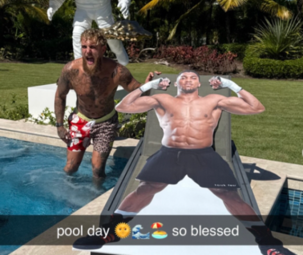 Collage of Jake Paul yelling in a pool next to a cutout of Anthony Joshua flexing on a lounge chair, with text "pool day ☀️🌊⛱️ so blessed".