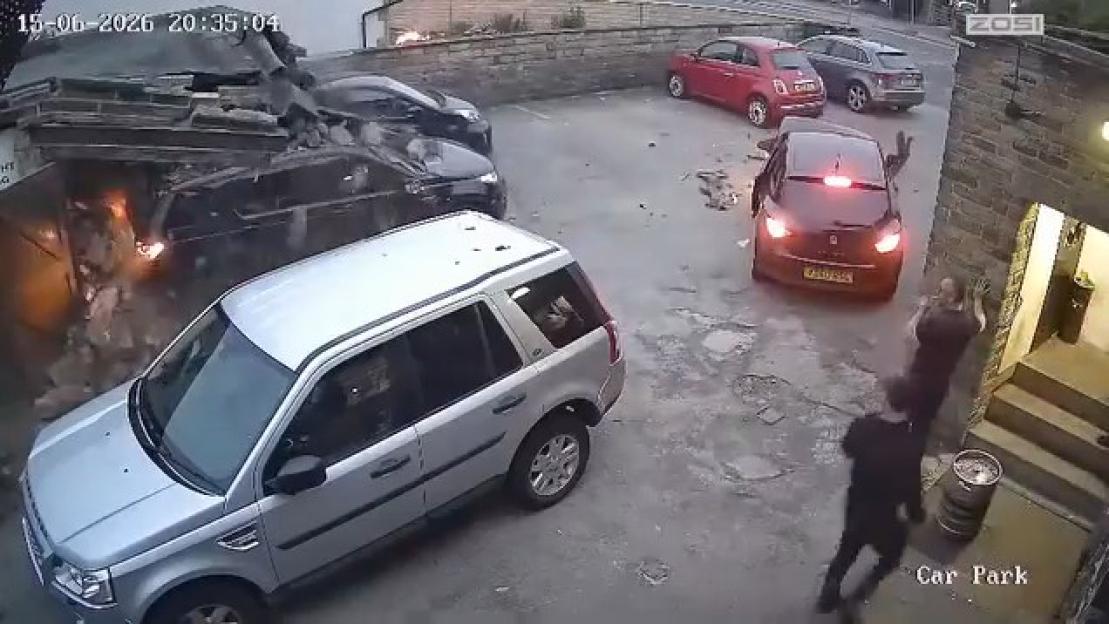 CCTV footage of a car crash in a car park with an explosion and people running.