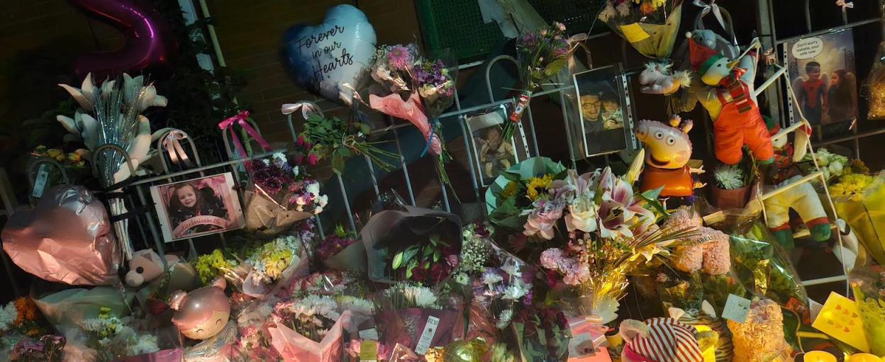 Memorial for Isabelle Rose Welsh with flowers, balloons, and photos.