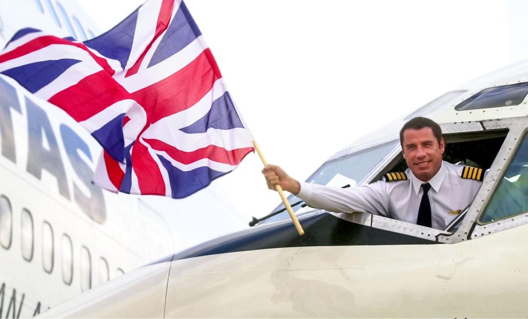 John Travolta, dressed as a pilot, waving a British flag from a plane cockpit.