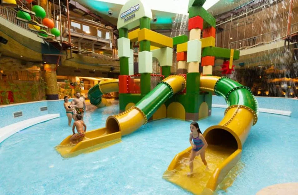 Children playing on colorful indoor water slides at Aquashow Indoor.