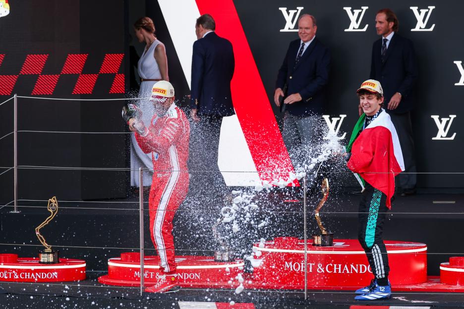 Lewis Hamilton and Kimi Antonelli spraying champagne on the podium at the Monaco F1 Grand Prix.