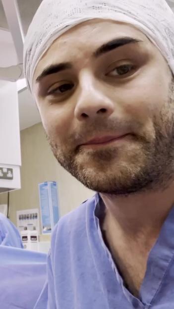 A man in a surgical cap and gown in an operating room.