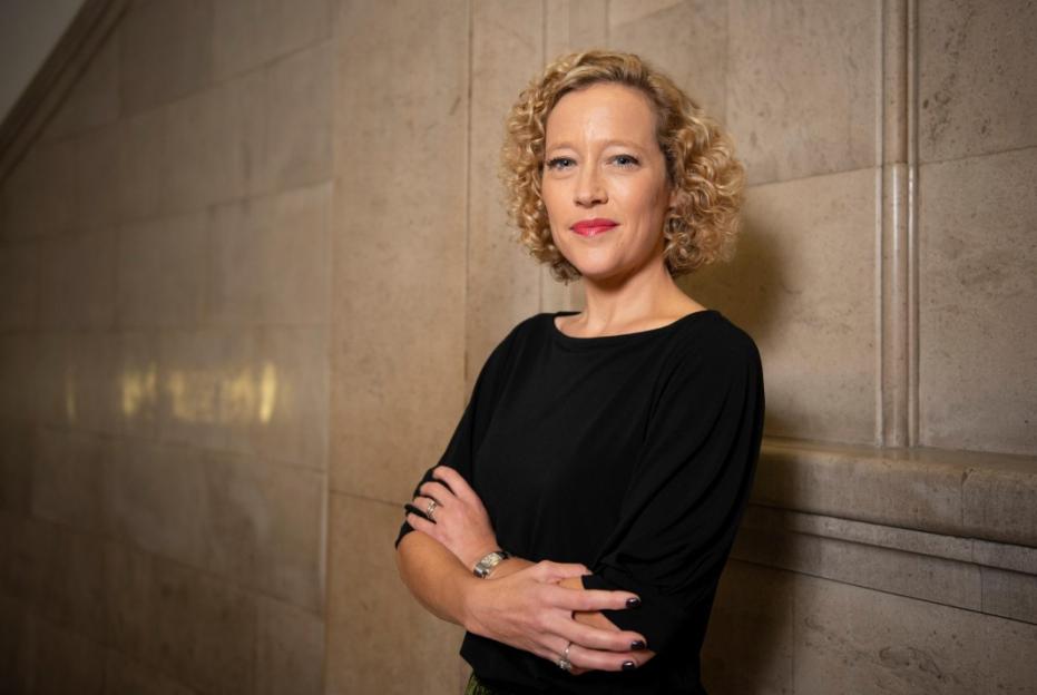 Cathy Newman, a Channel 4 journalist, standing with her arms crossed.