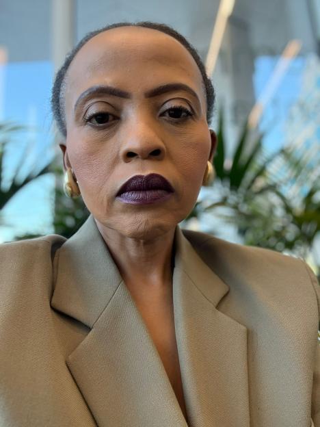 Charmaine Masoeu wearing a beige blazer and golden earrings, after weight loss.