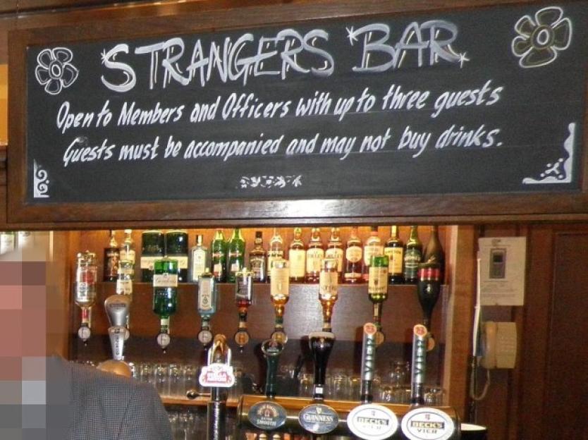Sign for "Strangers Bar" in the House of Commons, which reads: "Open to Members and Officers with up to three guests. Guests must be accompanied and may not buy drinks."