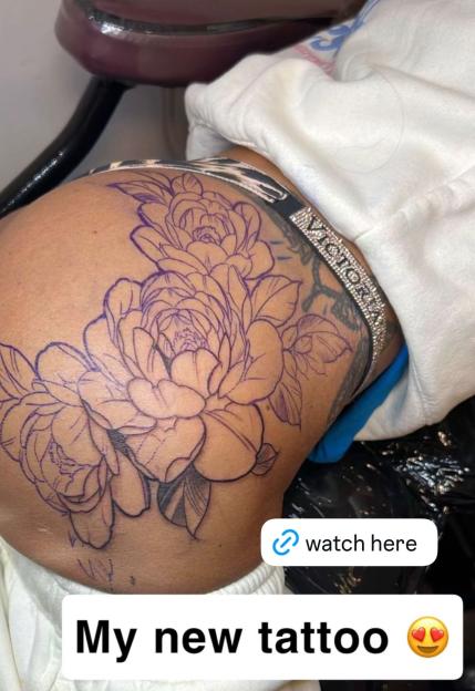Outline of a floral tattoo on a person's upper thigh, with text "My new tattoo" and an emoji with heart eyes.