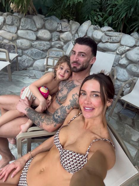 Jake Quickenden with his partner and child in an indoor pool area.