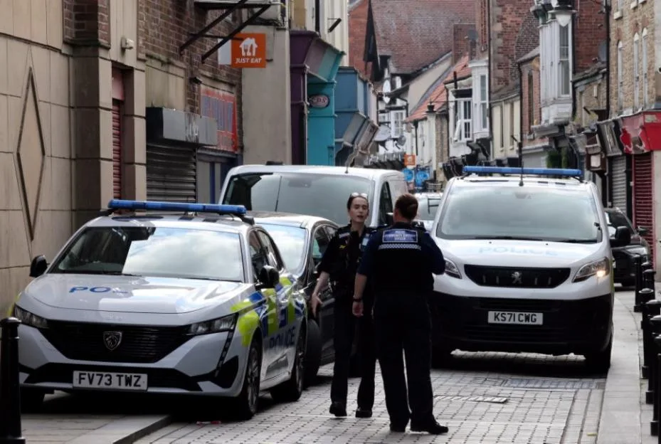 Police vehicles and officers on a street in Bishop Auckland, County Durham.