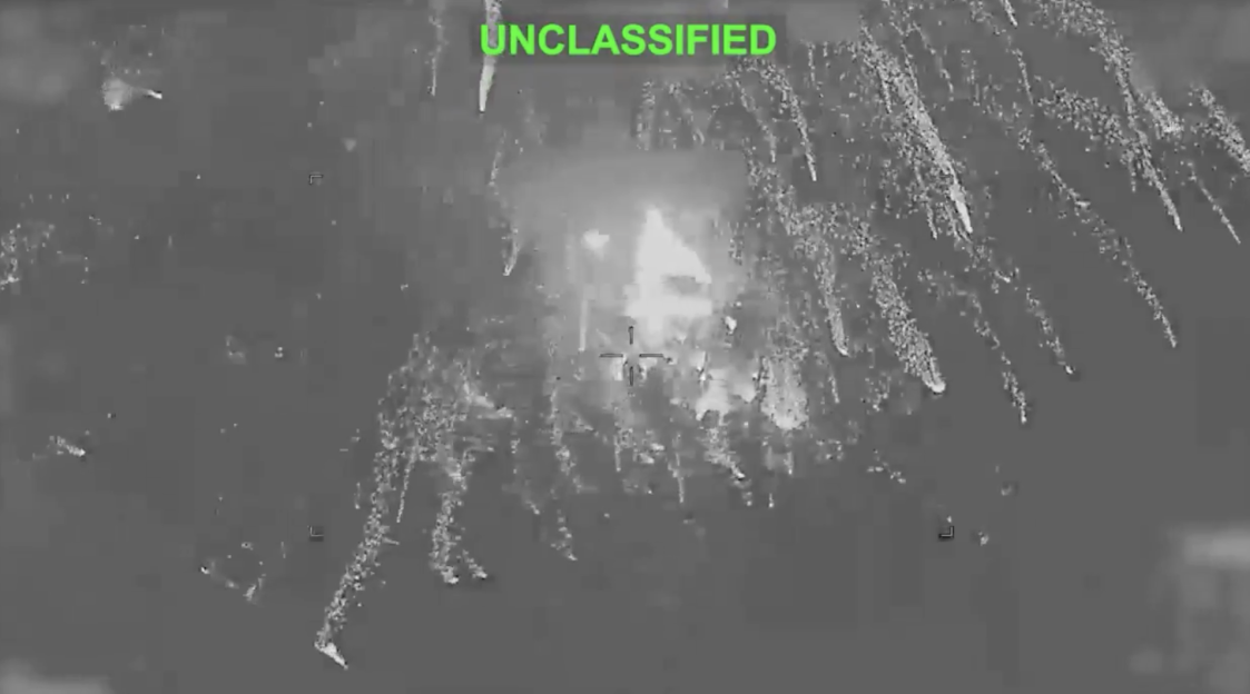 Thermal image of a missile strike impacting a target, with flares dispersing.