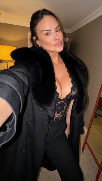 Rhian Sudgen in a black lace top and a coat with a fur collar.