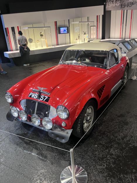 Red Austin-Healey 100/4 BN1 with "PWB 57" license plate on display at the Silverstone Museum.