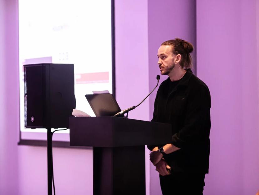 Thomas Delaney speaking at a podium with a microphone.