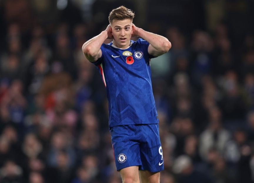Chelsea midfielder Conor Gallagher wearing a blue jersey and shorts, holding his head in a match against Wolverhampton Wanderers.