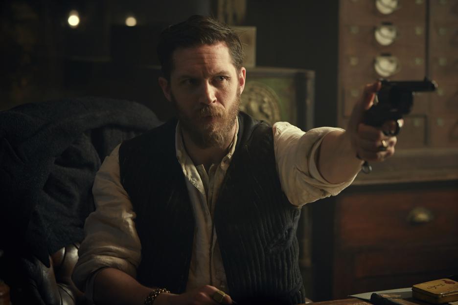Alfie Solomons (Tom Hardy) points a handgun.