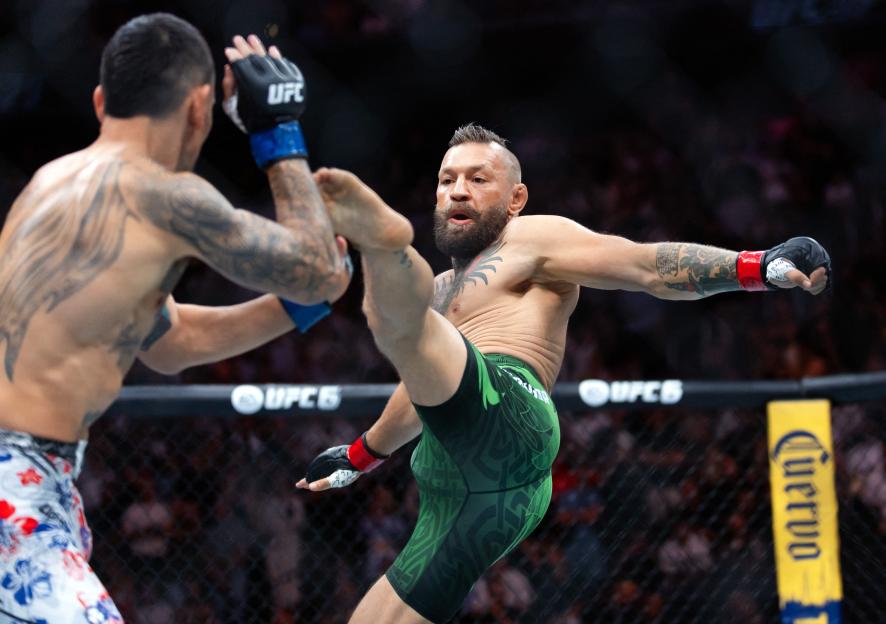 Conor McGregor attempts a flying kick against Max Holloway during UFC 329.