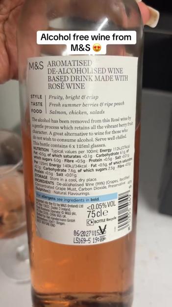 A close-up of a bottle of M&S aromatised de-alcoholised rosé wine, detailing its fruity and crisp style, fresh berry and peach taste, and suitability for pairing with salmon, chicken, and salads.