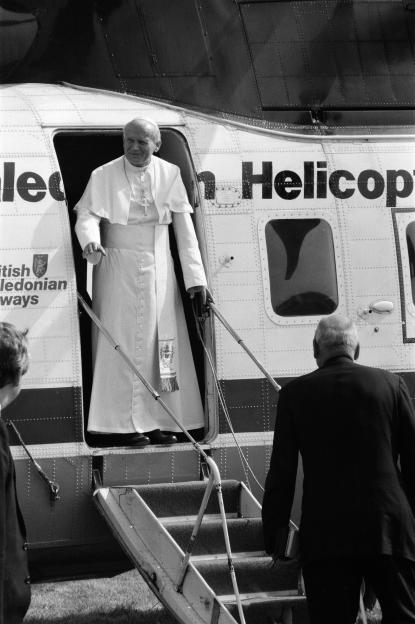 Pope John Paul II descending from a helicopter.
